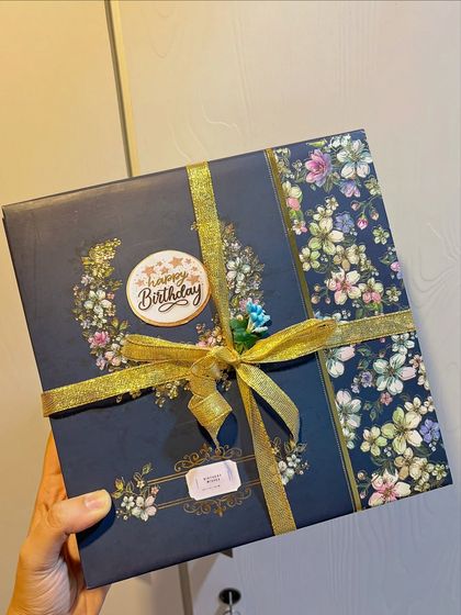 The exterior of the vintage hamper box, beautifully wrapped with floral paper and a gold ribbon. The presentation is just as important as the gifts inside.