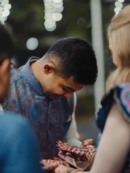 A sweet moment where the groom admires the bride's intricate henna stain.