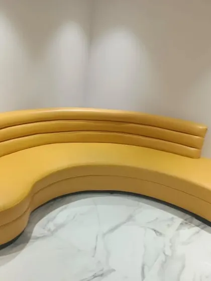 A custom-designed curved sofa in a bright yellow. I love creating unique furniture pieces like this that not only provide seating but also act as a piece of art in the room.