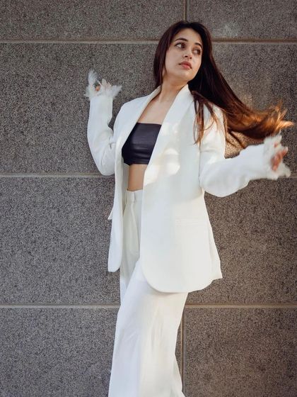 A client looking fabulous in her custom white power suit with unique feathered cuffs on the blazer sleeves. It’s all about those personal details.