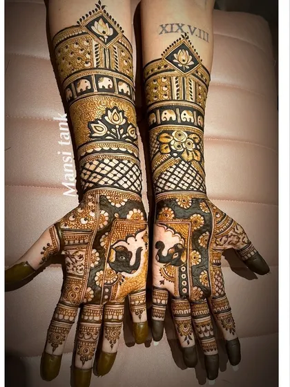 A beautiful example of combining modern and traditional styles for an engagement. This design features bold elephants, lotus motifs, and sharp check patterns, all with a rich, dark henna stain.
