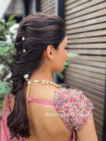 A close up of a textured pull-through braid, adorned with tiny, delicate hairpins for a touch of sparkle.