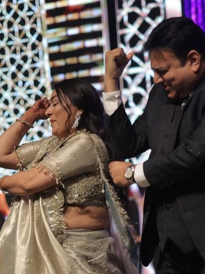 A fun, candid moment between a couple during a family dance. It's all about letting loose and having a good time.