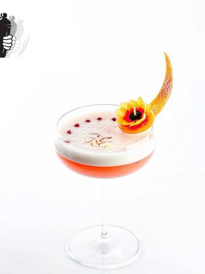 A beautiful sour cocktail with a frothy top, saffron strands, and an intricate flower garnish. This is a perfect example of our elevated garnish game.