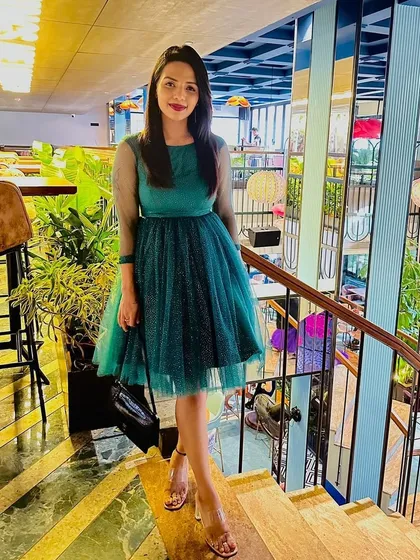 Another look at Pooja's custom green dress. The A-line silhouette and delicate details make it a fun and flirty option for any celebration.