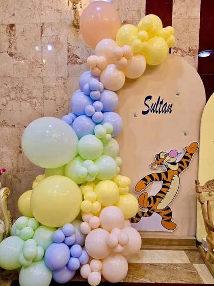 Detail of the pastel balloon cascade and Tigger cutout from the Pooh-themed party.