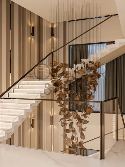 This angle showcases the staircase's floating design and the stunning, leaf-like metal sculpture that cascades down the stairwell, adding a touch of organic artistry to the modern space.