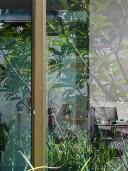 The reflection in the glass at the ATE Pune office merges the workspace with the garden outside. This visual layering is intentional, designed to ensure that even while working indoors, employees feel immersed in the natural environment.