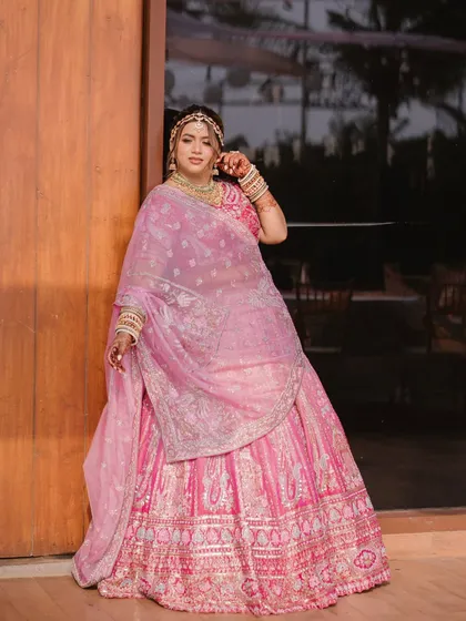 A full-length portrait of a happy bride by the resort doors. Her pose and smile radiate confidence and joy on her wedding day.