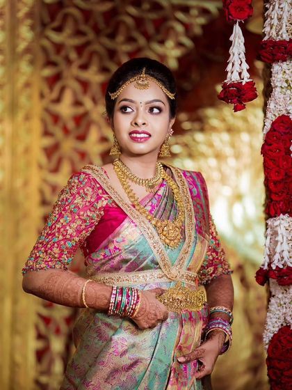 A candid moment of the bride during her Muhurtham. The makeup features a bold lip and defined eyes, perfect for a traditional South Indian wedding.