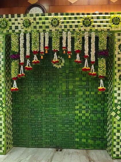A completely natural and eco-friendly backdrop made from woven coconut leaves, decorated with hanging jasmine garlands.