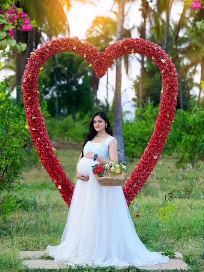 A stunning solo portrait in a light blue gown, framed by our red floral heart prop.
