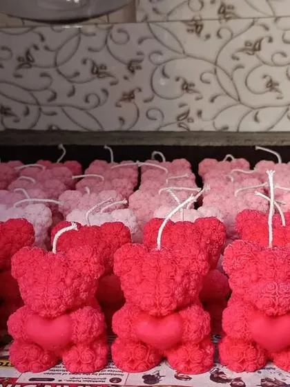 A large order of red and pink rose-textured teddy bear candles ready for Valentine's Day.
