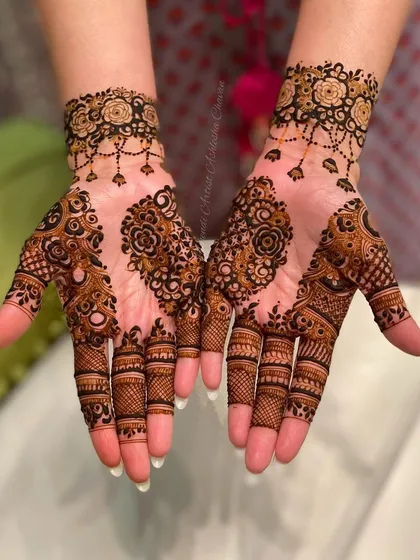 An Indo-Arabic design with a mix of floral and paisley motifs. The patterns are intricate and flow beautifully from the fingers to the wrist.