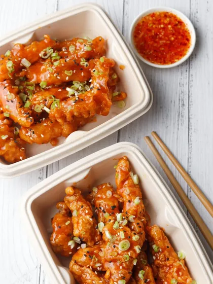 A flatlay of Korean chicken tenders in delivery boxes, shot with clean lighting for a catalogue-style menu.