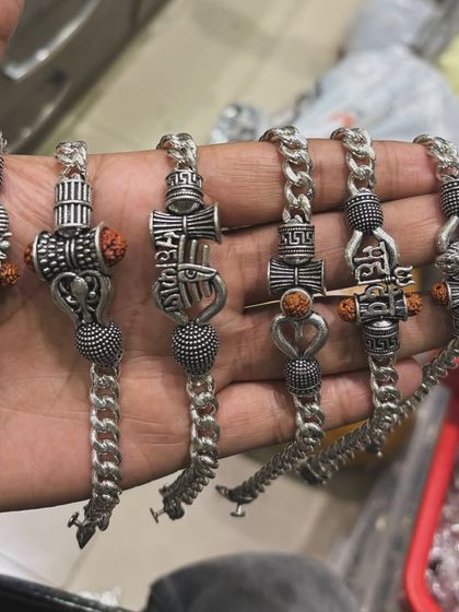 A collection of silver bracelets featuring various Mahadev-inspired designs like the Trishul and Damru, combined with Rudraksha beads. Perfect for Sawan and for devotees of Lord Shiva.