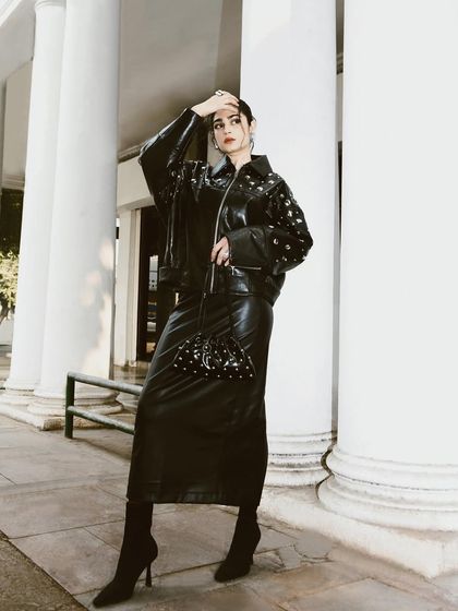 A powerful pose by Kavya Trehan against classic architecture. This shot combines street style with high fashion, showcasing the versatility of the look.