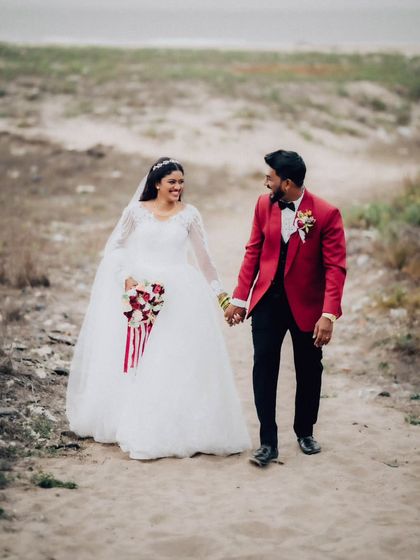 A candid shot of the couple walking hand-in-hand along a beach path. This relaxed portrait captures a natural and happy moment.
