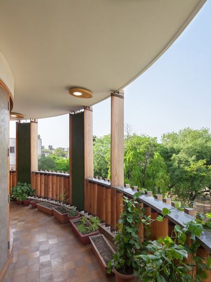 A view from a balcony in the Outré House, looking out into the neighborhood. The design provides sheltered outdoor spaces on each level, blending private living with the surrounding environment.