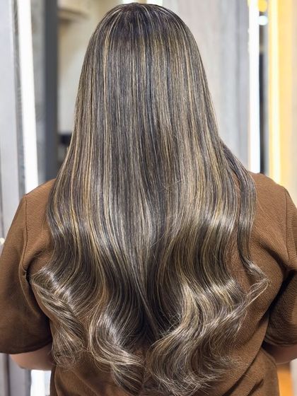 A back view of the creamy beige color, styled into perfect waves. The highlights are subtle and expertly blended.