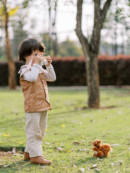 A little boy pretending to take a photo of a toy squirrel. It's always fun to see them mimic what I do.