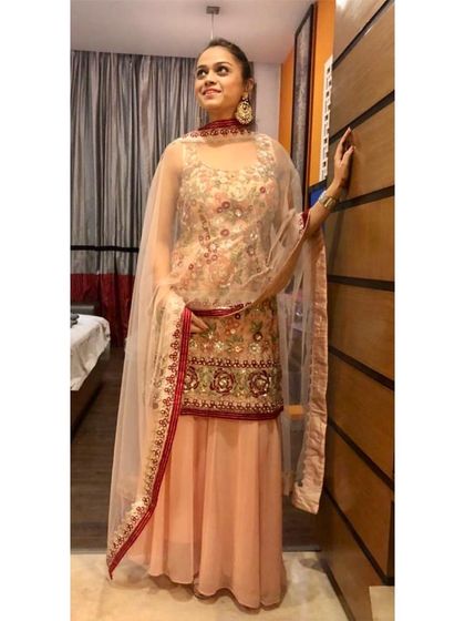 This pastel sharara suit is a wonderful choice for a daytime wedding event. The soft color palette combined with delicate floral embroidery and a sheer dupatta creates a romantic and feminine look.