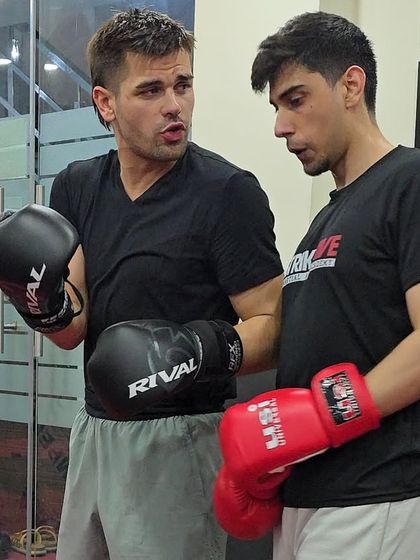 Two of our coaches discuss technique during a training session. Our collaborative coaching environment ensures a well-rounded curriculum for our students.