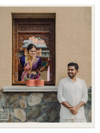 A creatively framed shot using a traditional carved window. This adds architectural interest and a sense of storytelling to the couple's portrait.