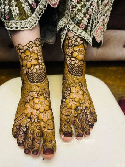 This image captures the full beauty of the floral foot design, showing how it complements the client's traditional attire.