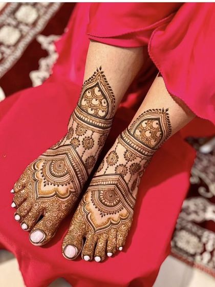 This foot mehndi features beautiful mandala and paisley patterns. The design is symmetrical and covers the feet elegantly, making it a perfect choice for a bride.