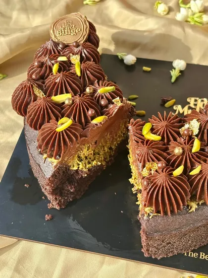 A slice of our Eid special cake, showing the rich brownie base and the crunchy, nutty kunafa and pistachio layer.