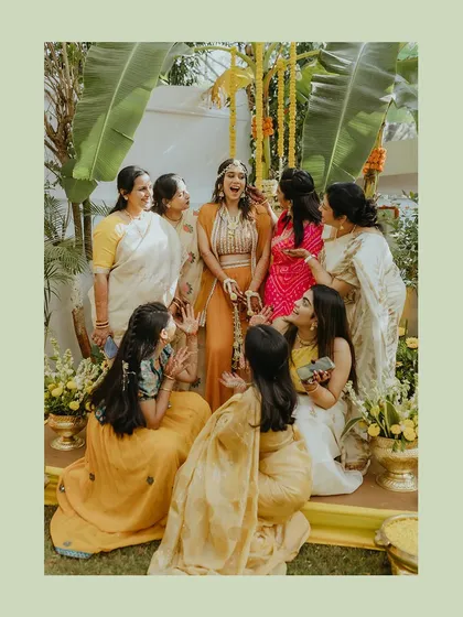 A beautiful candid moment of the bride sharing a laugh with her bridesmaids and family during her Haldi.
