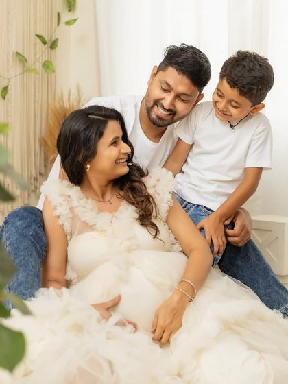 A candid moment of laughter and love. This family shot in casual white tees and jeans, paired with the elegant gown, is a perfect mix of fun and style.