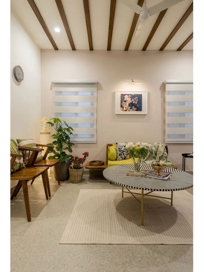 A single shot of the cozy living area, highlighting the wooden furniture and the soft light filtering through the blinds.
