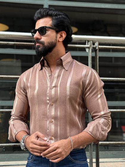 A three-quarter view of the brown satin striped shirt, showcasing its versatile style that pairs effortlessly with dark denim.