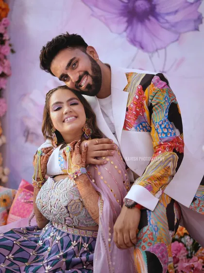 A happy and relaxed portrait of the couple, capturing their smiles and the colorful decor of their wedding celebration.