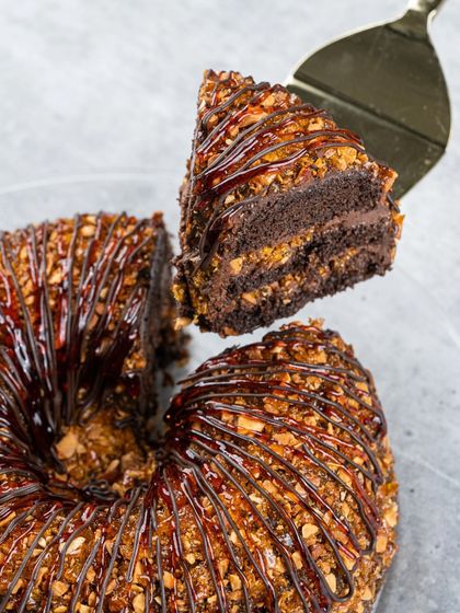 A slice of our Chocolate Praline Cake, showing the rich layers of chocolate cake and the crunchy, caramelized nut topping.