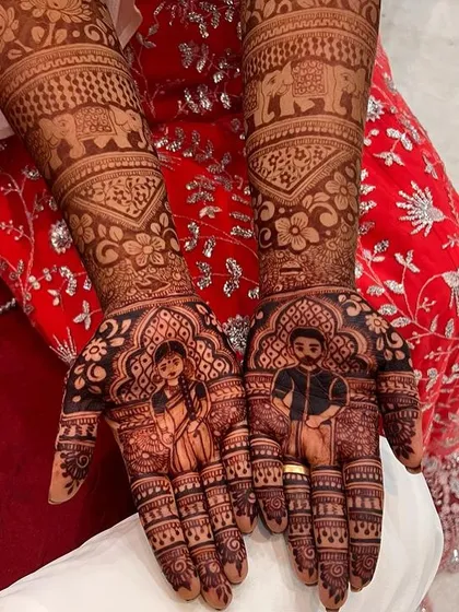 A portrait mehendi telling a story of love. This design features detailed figures of the bride and groom, surrounded by intricate patterns and elephant motifs.