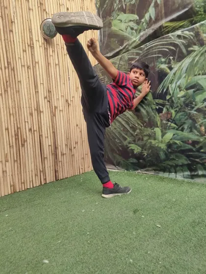 A student demonstrates a perfect side kick, showcasing excellent flexibility and technique. The side kick is one of the most powerful and versatile weapons in a martial artist's arsenal.