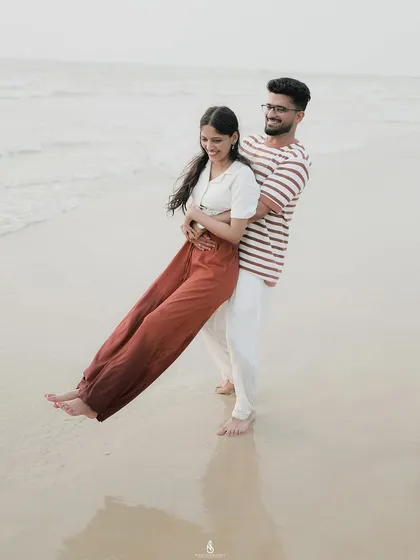A joyful, carefree lift on the wet sand. Playful moments like this make for dynamic and memorable pre-wedding photos.
