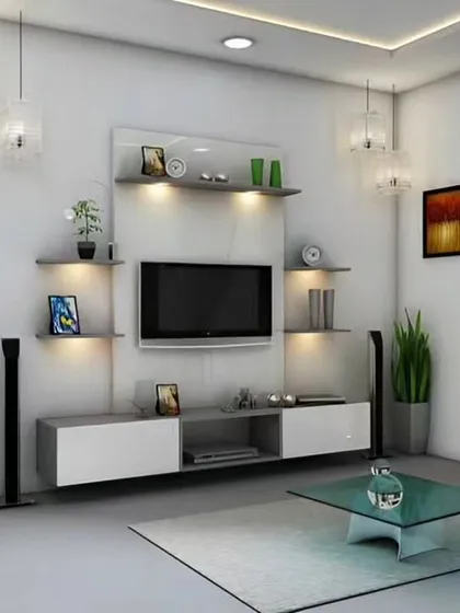 A minimalist living room featuring a white and grey wall-mounted TV unit with asymmetrical shelving. Backlighting adds a soft glow, enhancing the clean lines and modern aesthetic of the space.