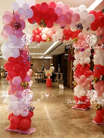 A festive red, pink, and white balloon arch creates a cheerful entrance, perfect for a Christmas or winter-themed birthday party.