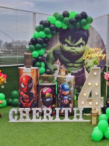 A full shot of the Hulk and Avengers themed birthday decor. The arrangement includes a personalized name sign, character-wrapped plinths, and a dynamic balloon arch, perfect for young superhero fans.