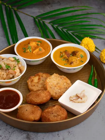 A beautifully arranged Upvas (fasting) thali for Shivratri. This top-down shot showcases a complete, traditional meal.