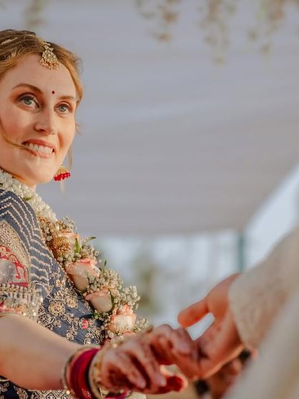 The bride's loving gaze as she holds her groom's hand during the Pheras.
