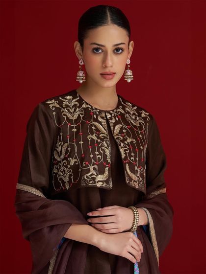 A rich brown kurta set featuring a stunningly embroidered short jacket, showcasing intricate bird and floral motifs in gold thread.
