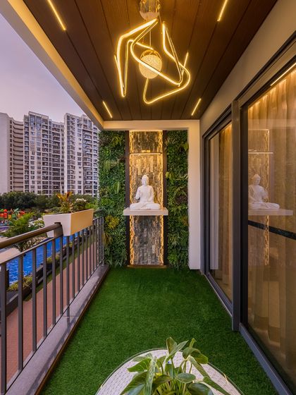A zen-inspired balcony with a vertical garden, a calming Buddha statue, and a small water feature. The artificial grass and modern lighting create a perfect spot for meditation or enjoying a quiet moment.