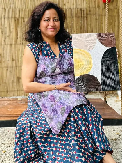 A participant proudly displays her finished texture art piece. She created a beautiful composition of circles with intricate line work, showcasing a wonderful sense of balance and color.
