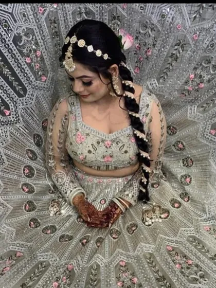 A stunning top-down view of a grey lehenga with pink and silver embroidery. The intricate details and the bride's beautiful braid make this a captivating shot.