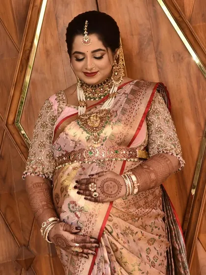 A stunning mom-to-be admiring her baby bump. The intricate mandala on her palm and the detailed patterns on her arms add a touch of traditional elegance to her baby shower look.